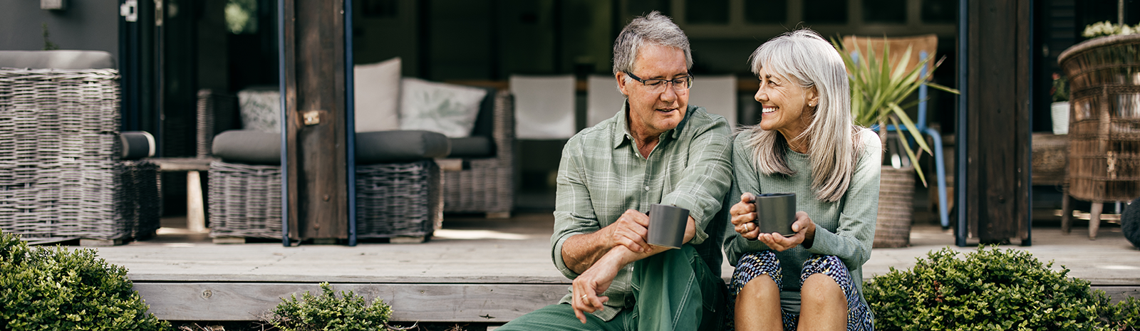 Couple in their 60s having coffee on the steps