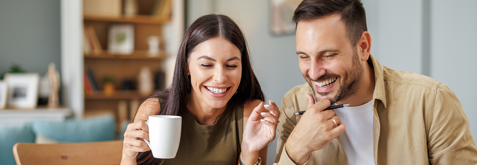 smiling woman and man drinking coffee
at table