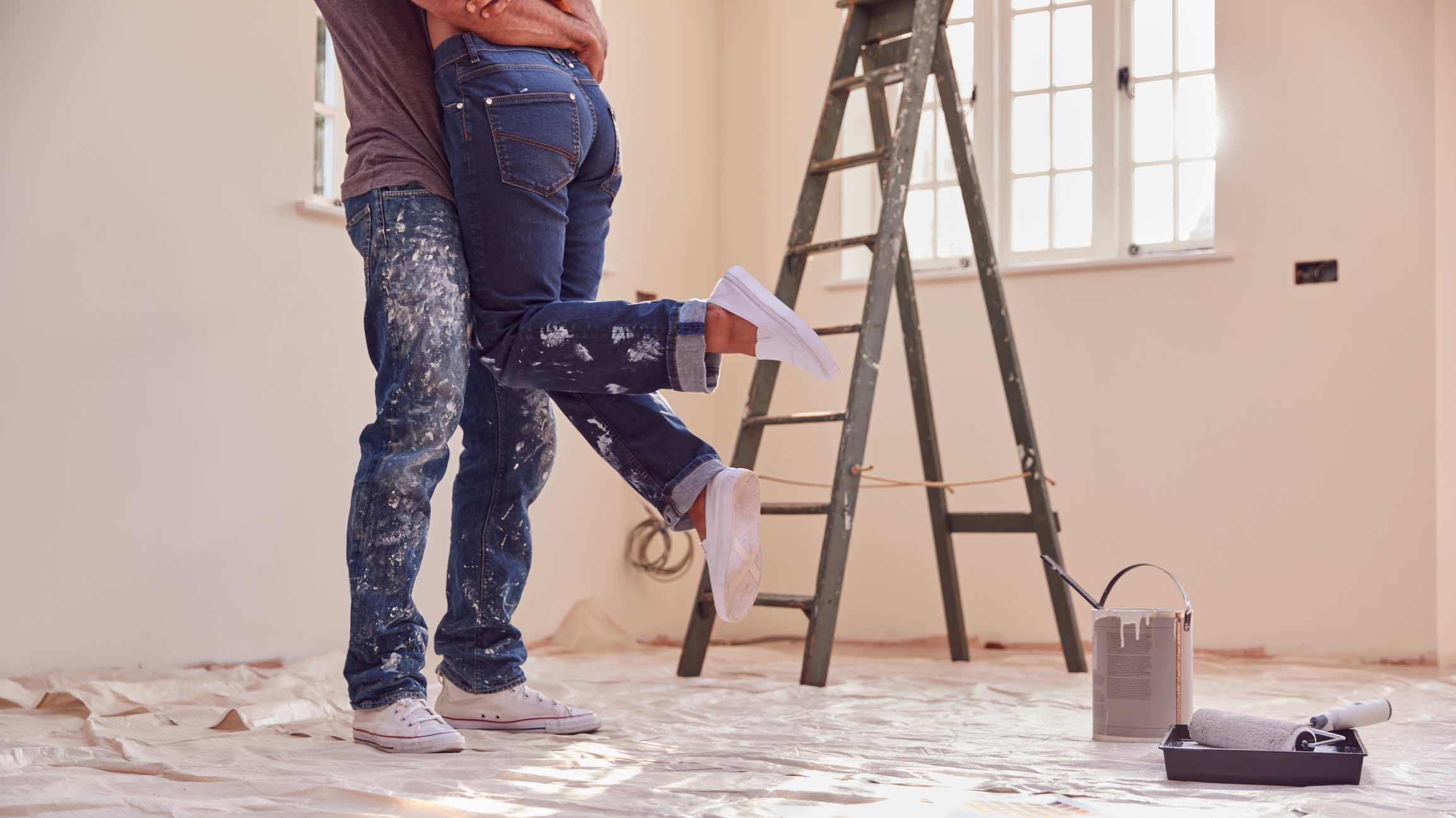 Couple painting a room as part of a home renovation