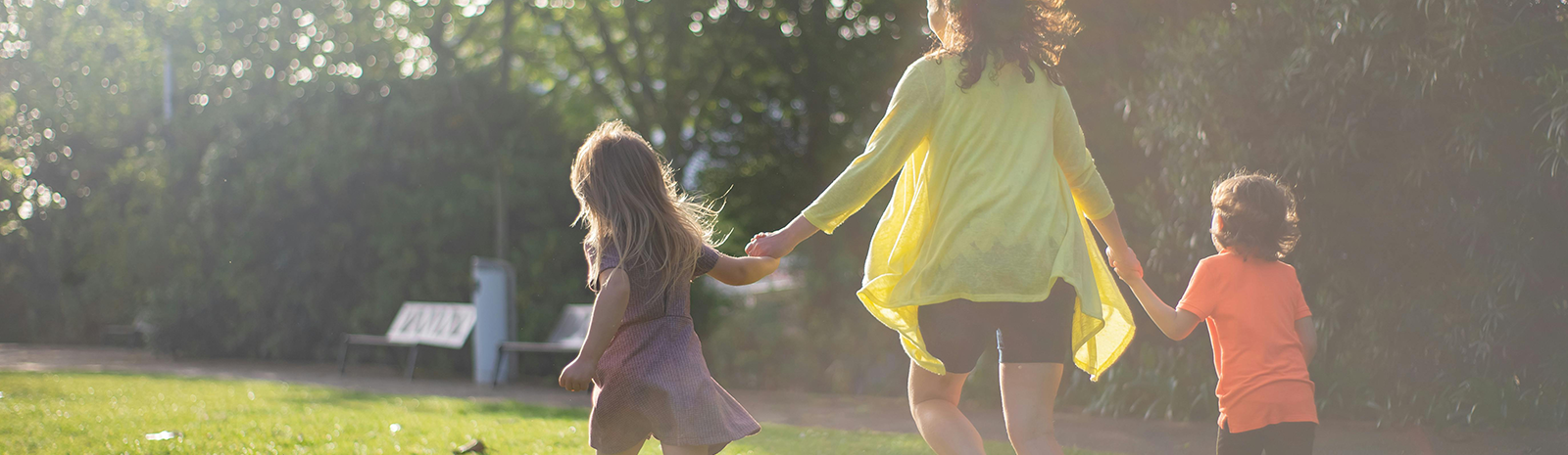 Mom running with her two kids in a park