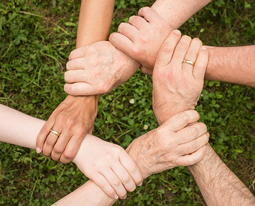 Hands of different people joined in a circle