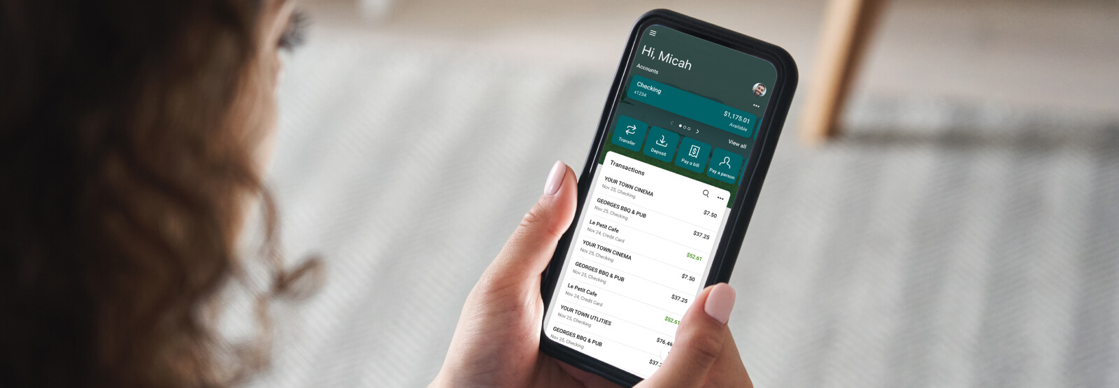 Woman holding a smartphone with banking app on the screen