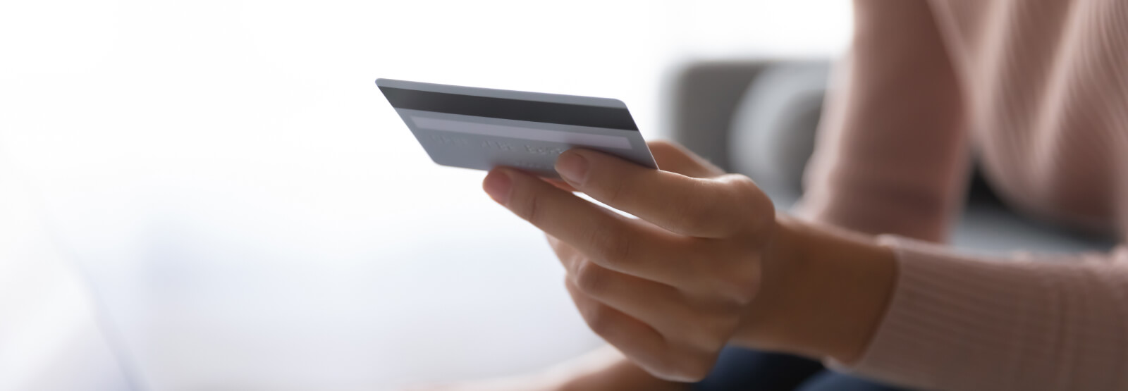 Close up of a person's hands holding a debit card